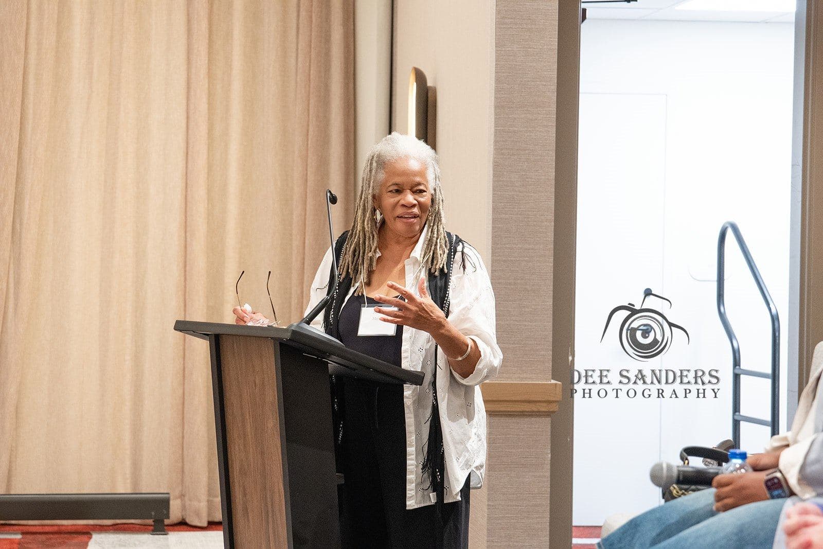 A speaker addressing the room from the podium