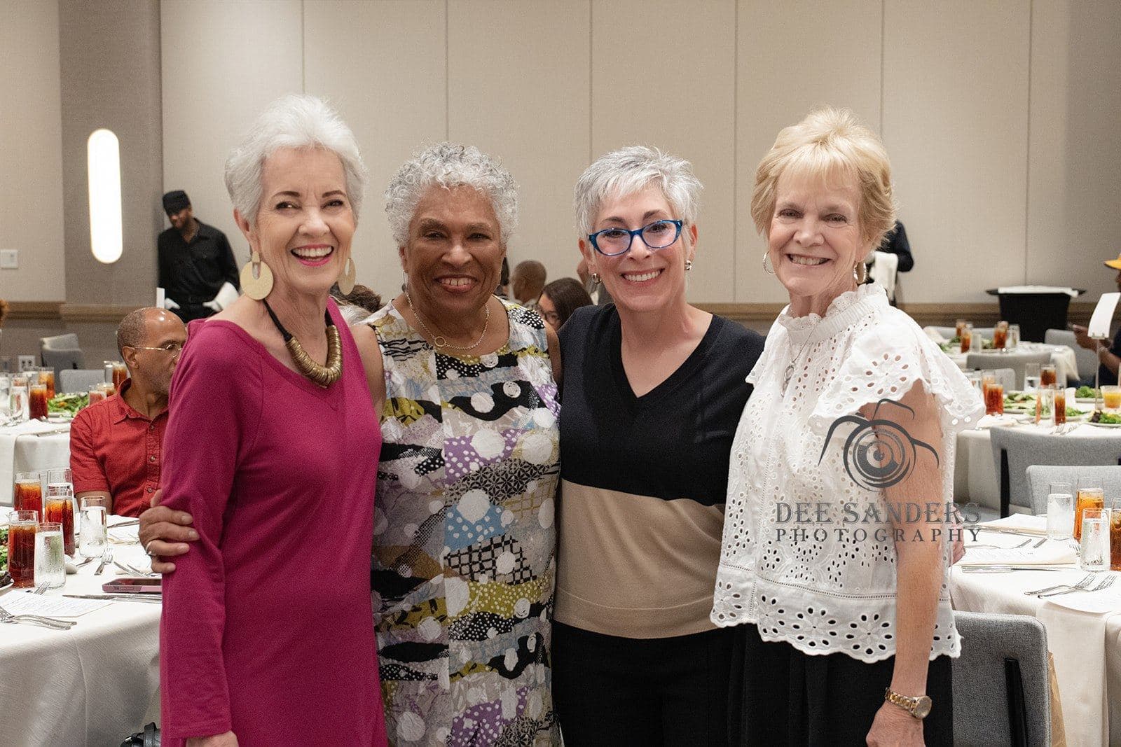 Four attendees posing together at dinner