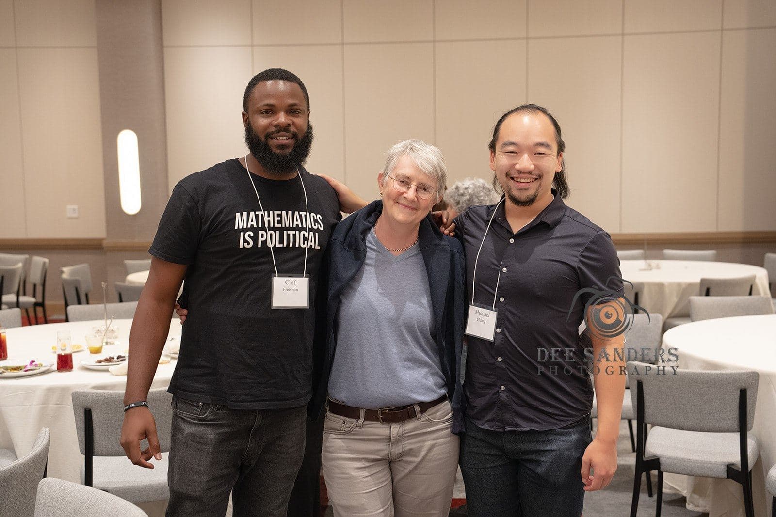 Three attendees smiling together at the dinner