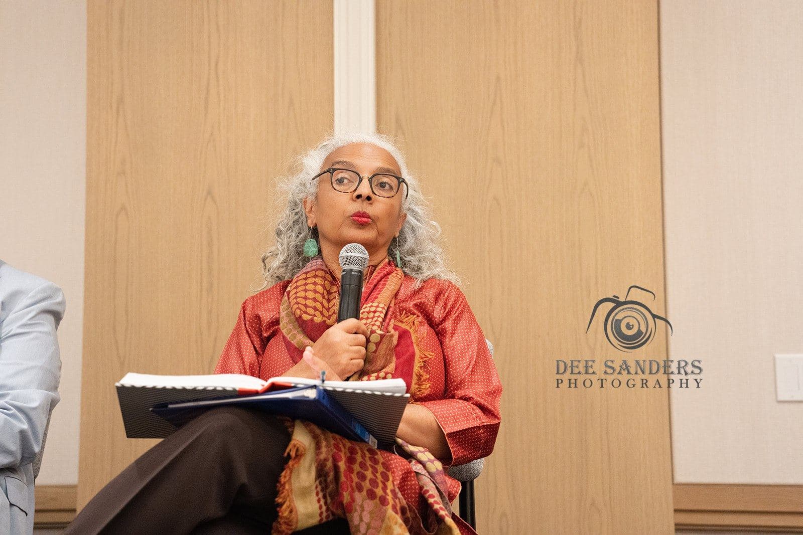 A speaker in a red jacket answering a question