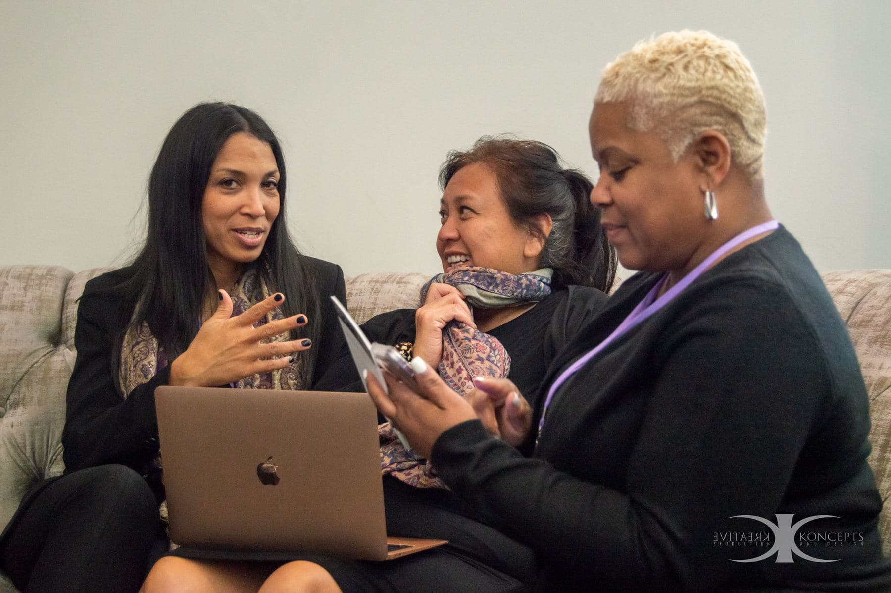 Three attendees laughing together on a couch