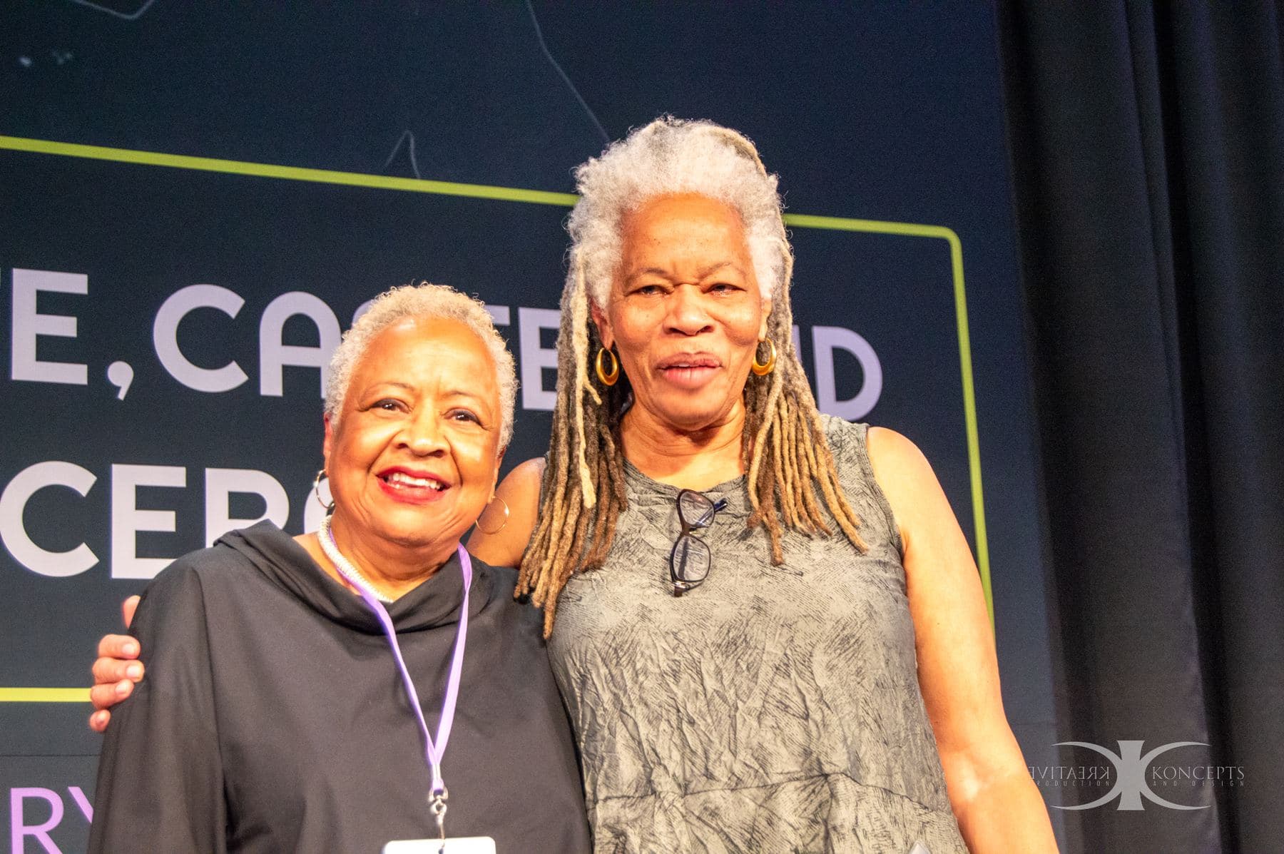 Two attendees smiling together on stage