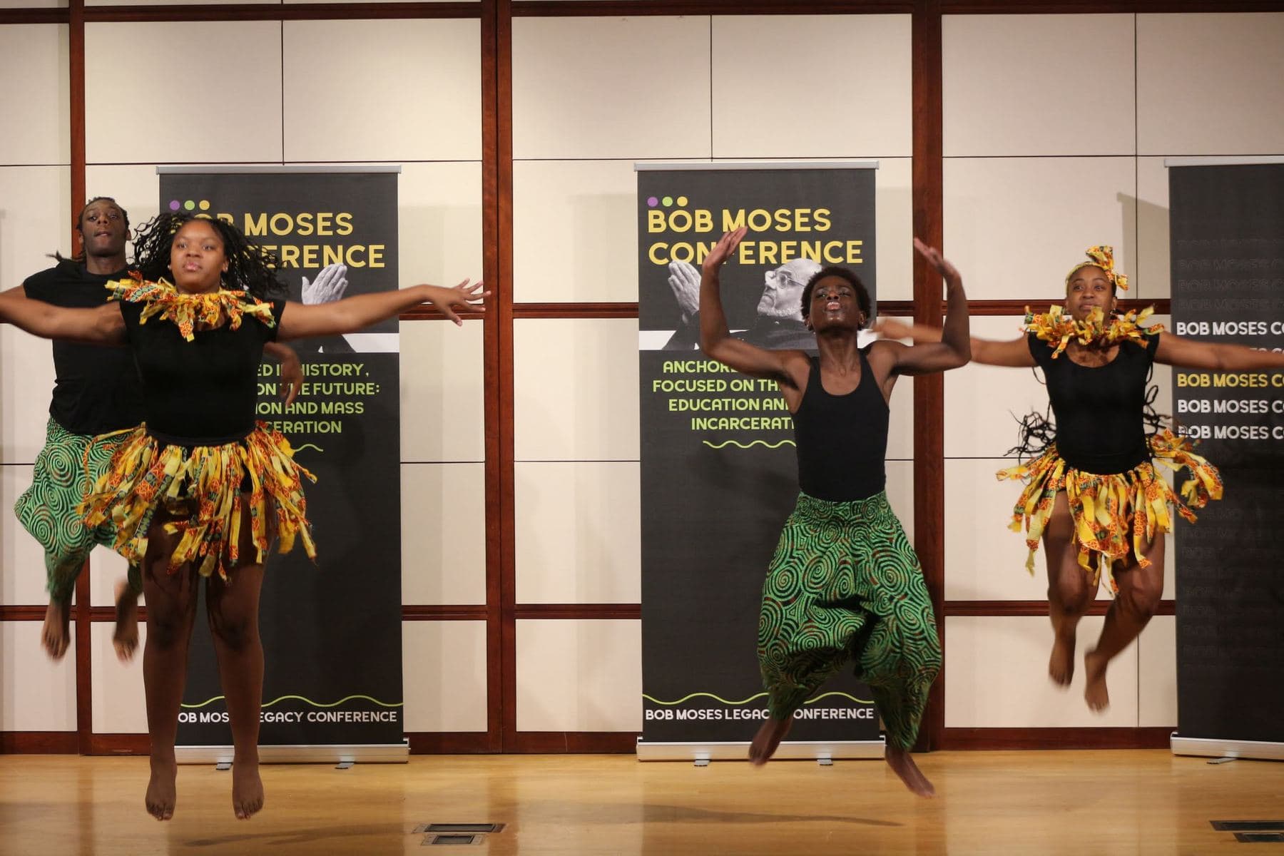 Dancers performing on stage in front of the conference banner